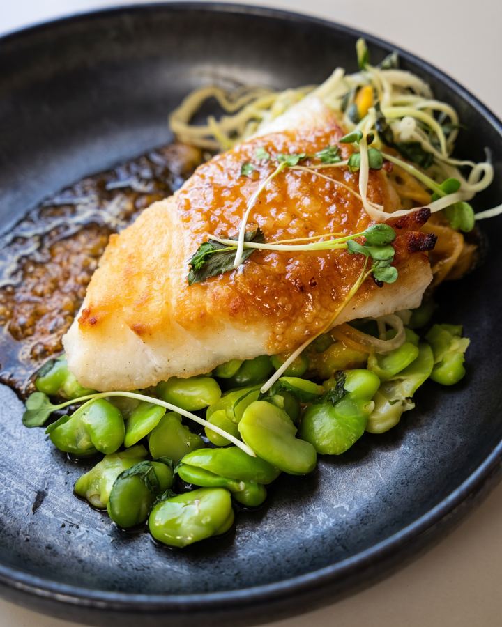 Glazed fish over fava beans